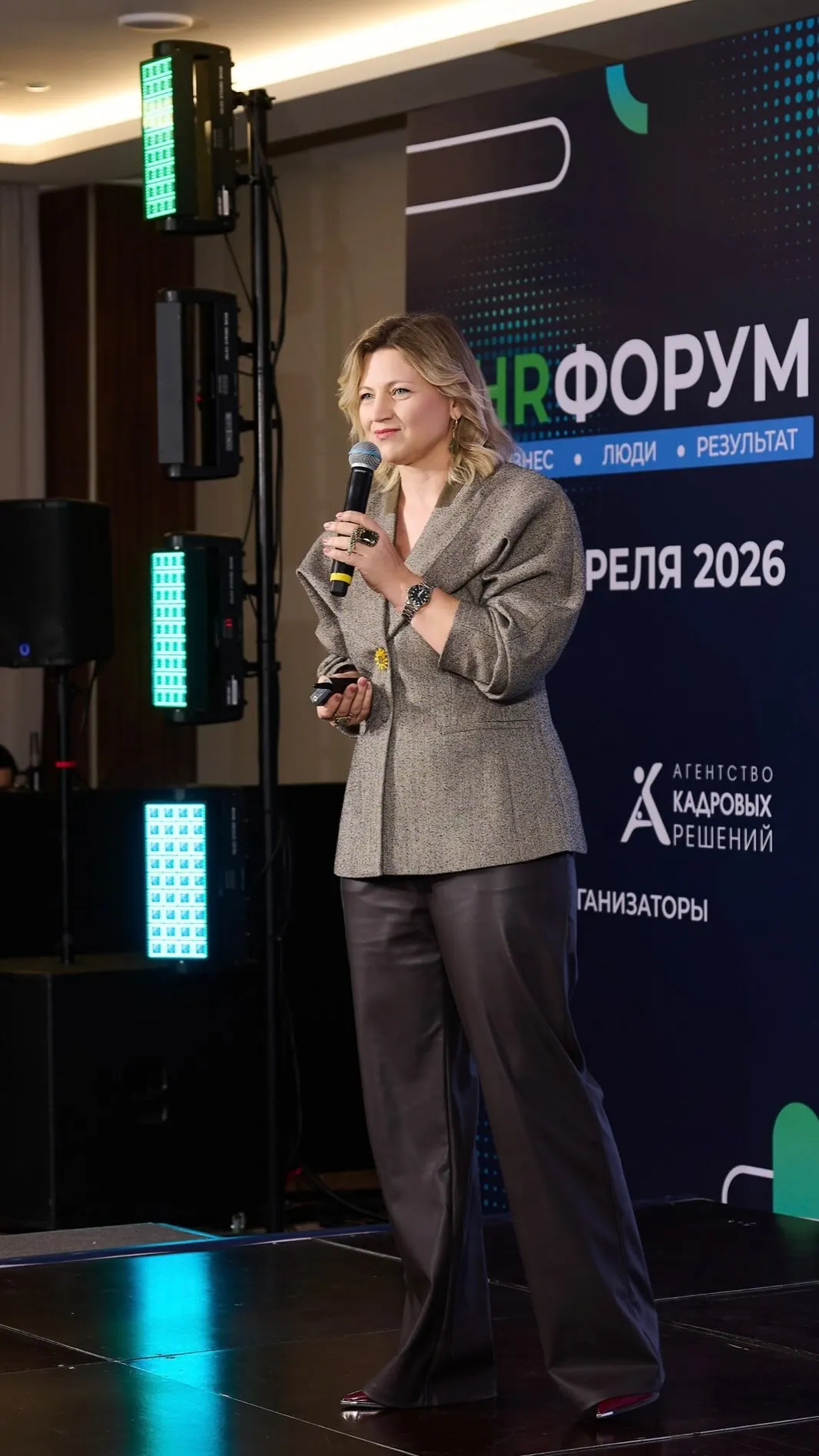 Ирина Сальникова выступает на сцене HR-форума с микрофоном